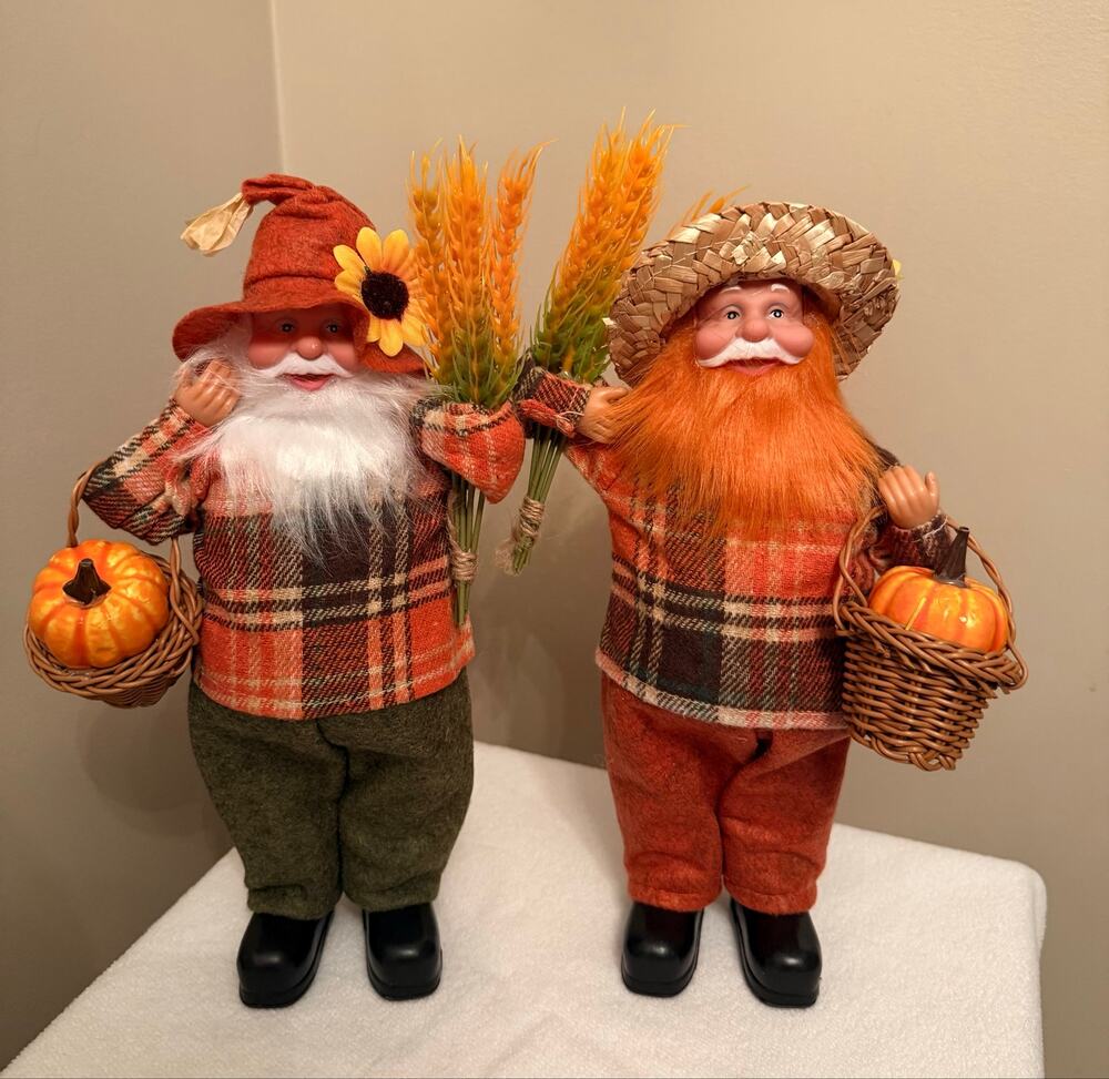 Two autumn harvest grandfather gnomes or old man dolls holding baskets stalks